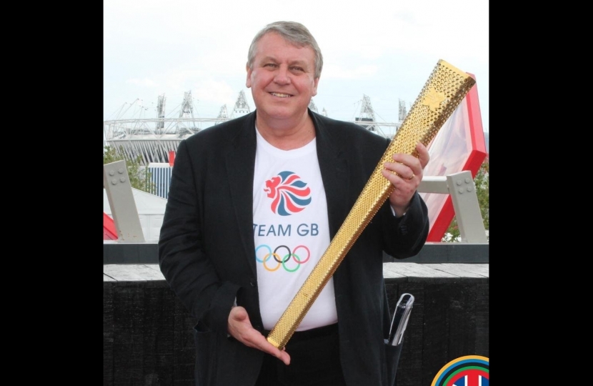 Graham Postles MBE holding the Olympic Torch