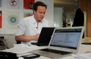 David Cameron with two laptops.