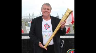 Graham Postles MBE holding the Olympic Torch